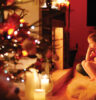 Young mother and her daughters by a fireplace on Christmas