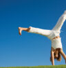 Young woman doing cartwheel on grass