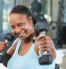 Mature woman in health club, lifting weights.