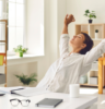 woman sitting at desk taking a stretch