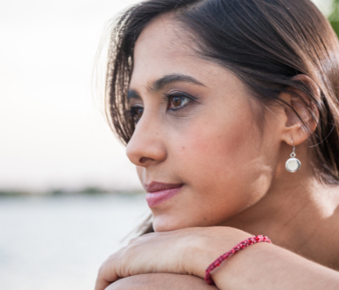 Woman resting chin on hands, gazing and thinking